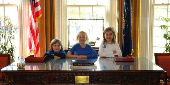 student trio behind the president's desk